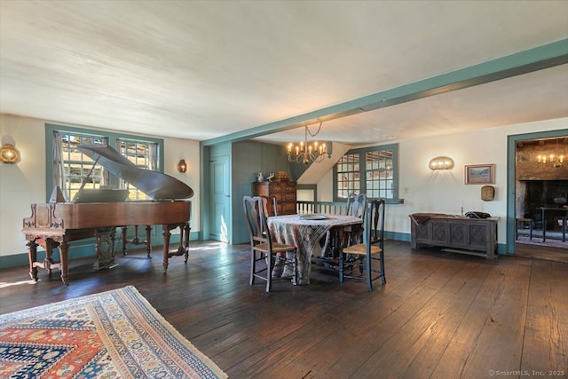 dining space with hardwood / wood-style floors, baseboards, and a chandelier