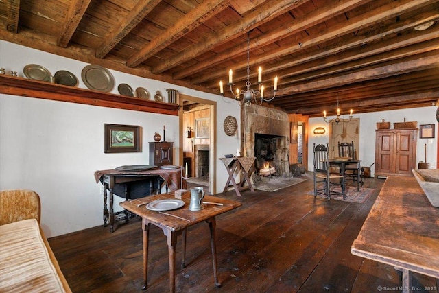 living area featuring beamed ceiling, wood ceiling, hardwood / wood-style floors, a warm lit fireplace, and an inviting chandelier