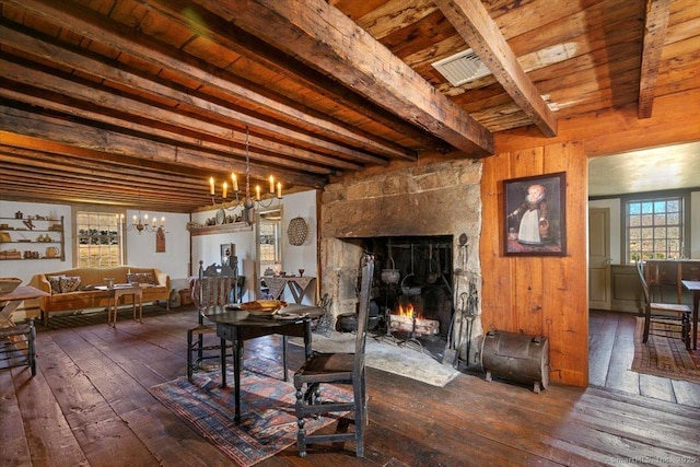 dining space with beamed ceiling, dark wood finished floors, wooden ceiling, a fireplace, and a chandelier