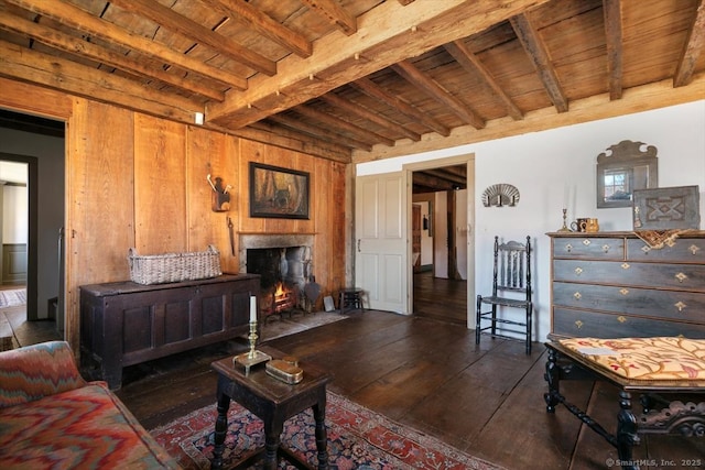 living room with wooden ceiling, hardwood / wood-style flooring, a fireplace, and beamed ceiling