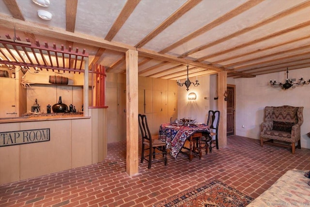 dining space featuring a notable chandelier and brick floor