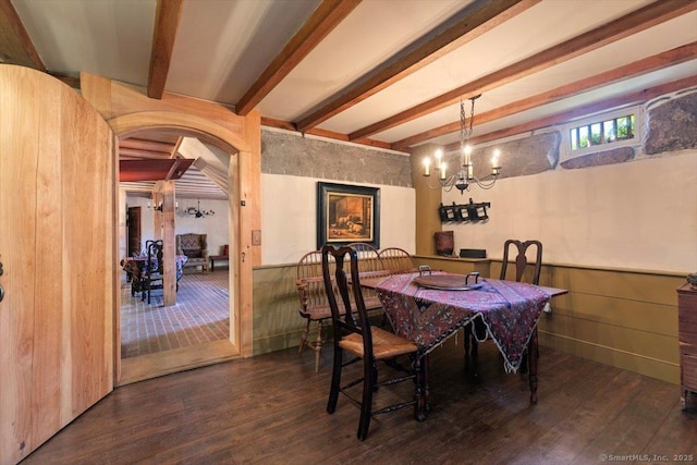 dining area with arched walkways, beam ceiling, wood finished floors, and wainscoting