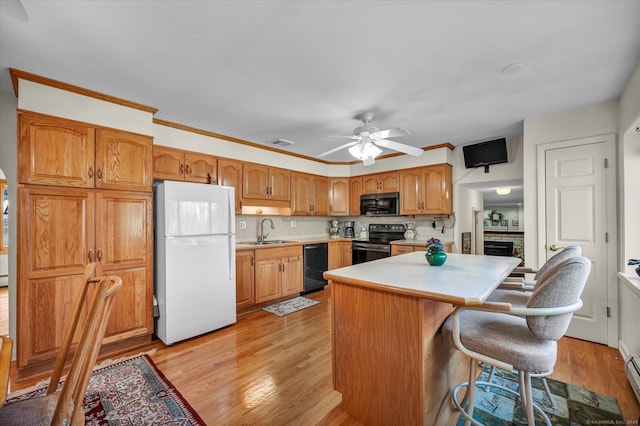 kitchen with light countertops, visible vents, black appliances, and light wood finished floors