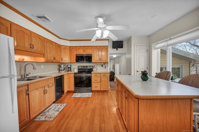 kitchen with visible vents, light wood-style floors, light countertops, black appliances, and a sink