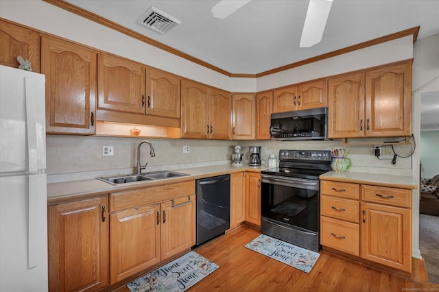 kitchen with electric range, visible vents, dishwasher, freestanding refrigerator, and a sink