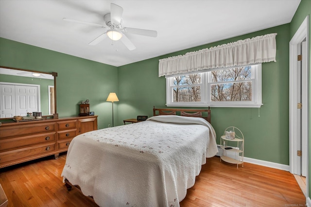 bedroom featuring a ceiling fan, baseboards, and wood finished floors