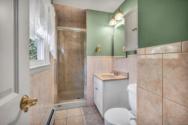 full bathroom featuring a shower stall, tile walls, baseboard heating, and tile patterned flooring