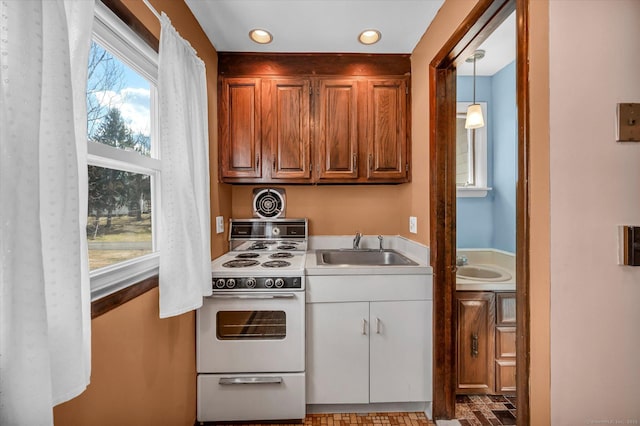 kitchen with recessed lighting, white electric range, a sink, light countertops, and pendant lighting