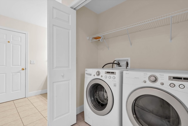 washroom featuring light tile patterned floors, baseboards, independent washer and dryer, and laundry area