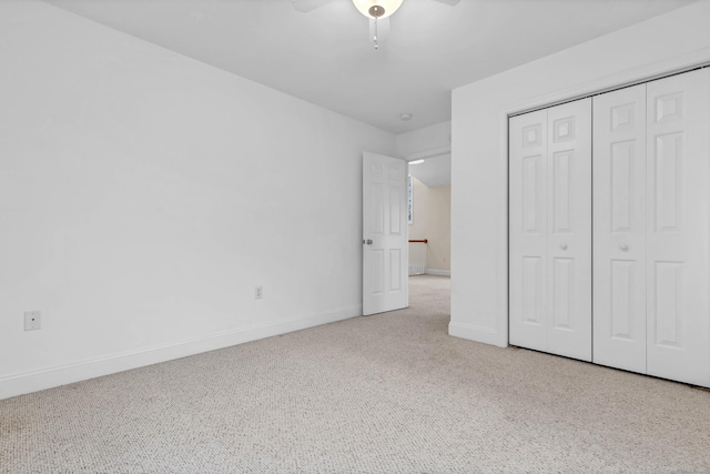 unfurnished bedroom featuring carpet floors, baseboards, a closet, and ceiling fan