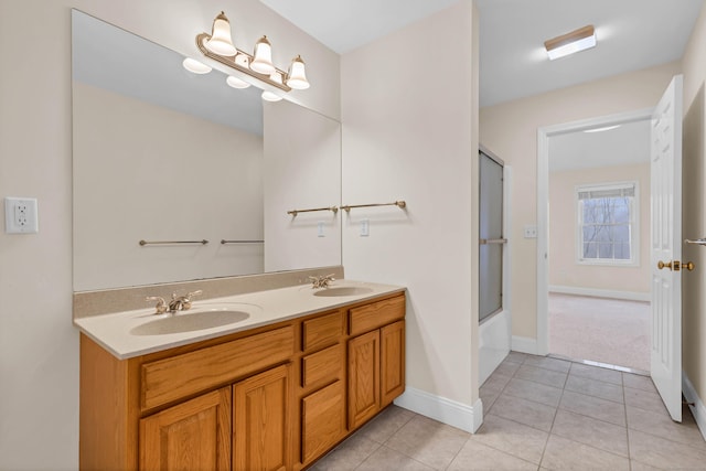 bathroom with tile patterned flooring, double vanity, baseboards, and a sink