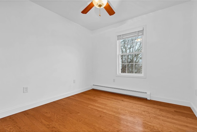 empty room with a baseboard heating unit, light wood-style floors, baseboards, and a ceiling fan