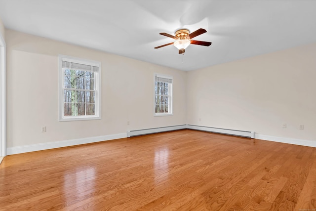 spare room featuring plenty of natural light, baseboards, light wood-style floors, and a ceiling fan