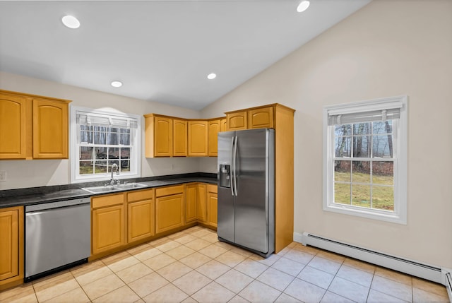 kitchen with a baseboard radiator, lofted ceiling, a sink, appliances with stainless steel finishes, and dark countertops