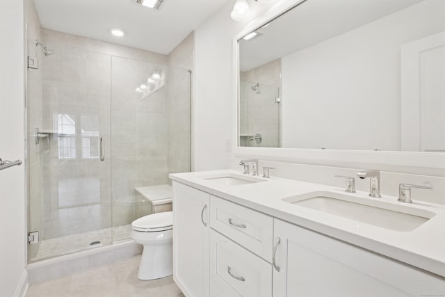 full bathroom featuring toilet, a stall shower, double vanity, and a sink