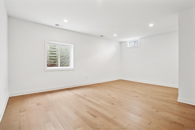 empty room with baseboards, light wood finished floors, visible vents, and recessed lighting