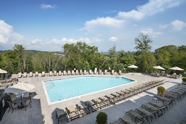 community pool with a patio and fence