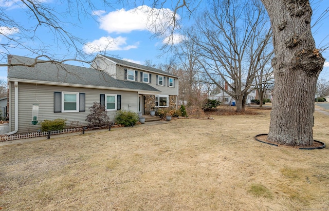 view of front of house featuring stone siding, a shingled roof, and a front yard