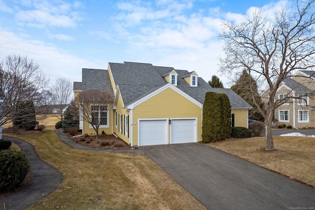 view of front of property with driveway, a front lawn, roof with shingles, and an attached garage