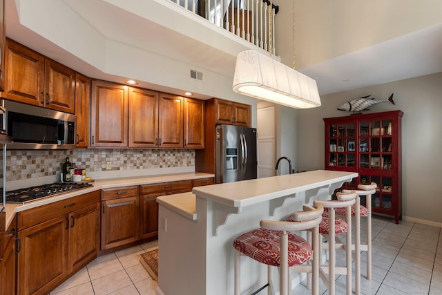 kitchen featuring appliances with stainless steel finishes, visible vents, and brown cabinets