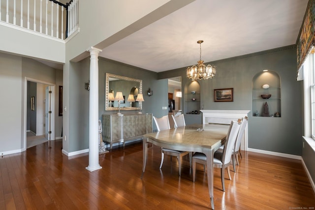 dining room with baseboards, built in features, hardwood / wood-style flooring, and ornate columns