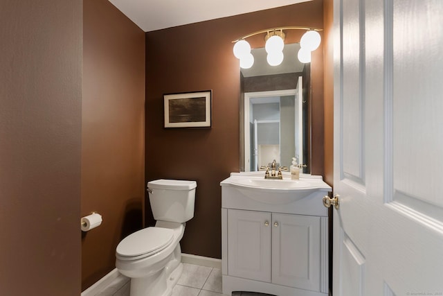 half bathroom featuring baseboards, vanity, toilet, and tile patterned floors