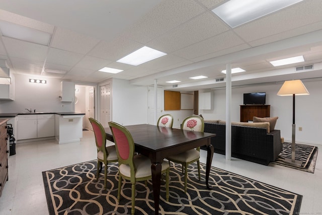 dining area featuring light floors, a drop ceiling, and visible vents