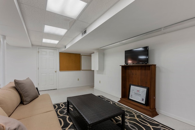 living area featuring baseboards, visible vents, and a drop ceiling