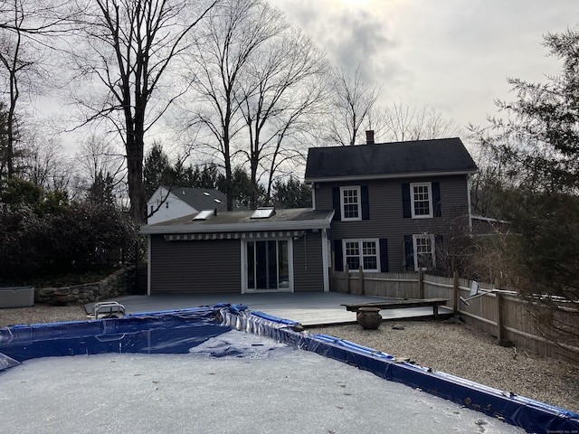 back of property featuring a garage, a patio area, a chimney, and fence