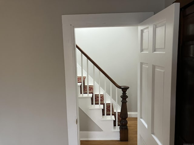 stairs featuring wood finished floors and baseboards