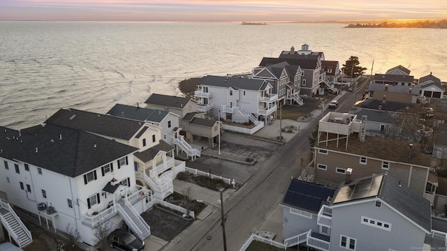 aerial view at dusk with a residential view and a water view