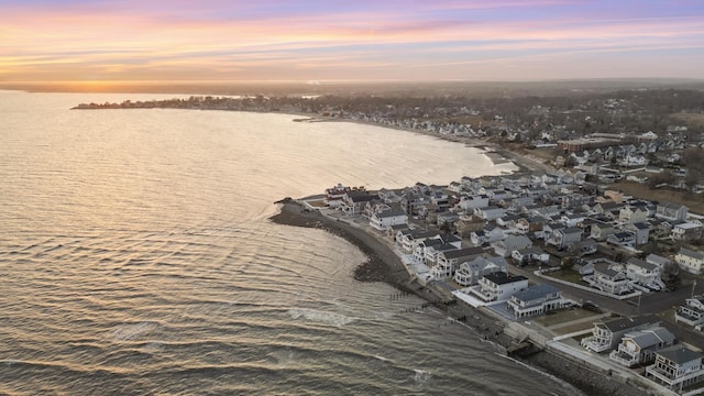 aerial view at dusk featuring a residential view and a water view