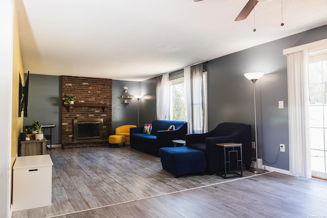 living area with plenty of natural light, a fireplace, and wood finished floors