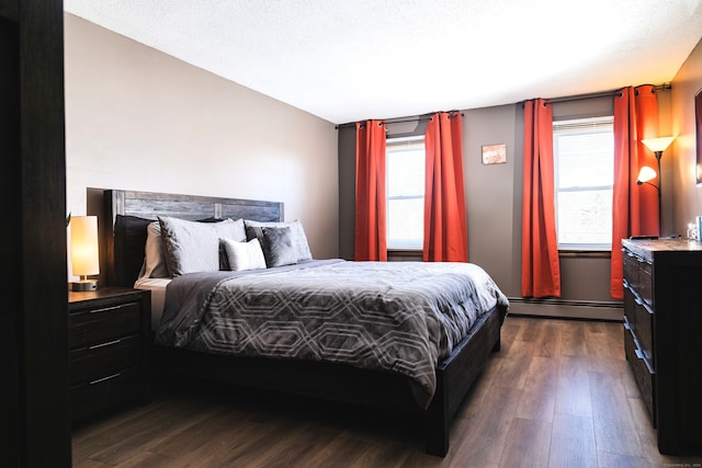 bedroom with dark wood-type flooring, a baseboard radiator, and multiple windows