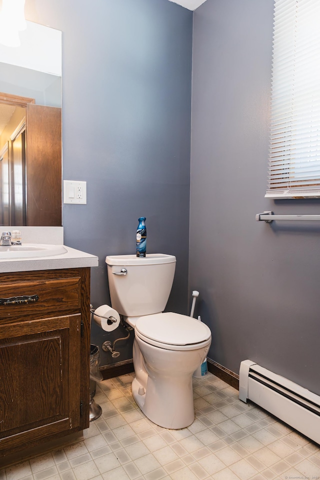 bathroom featuring a baseboard radiator, vanity, toilet, and baseboards