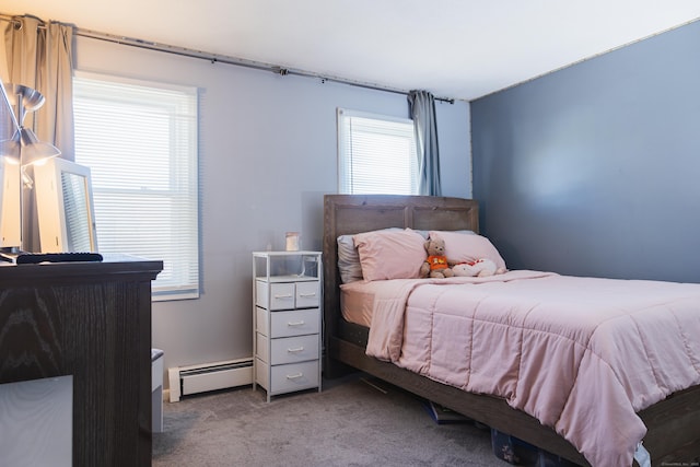 bedroom with a baseboard heating unit and carpet flooring