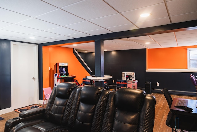 home theater room with recessed lighting, a drop ceiling, baseboards, and wood finished floors