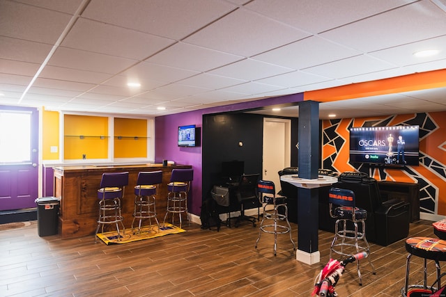 bar featuring indoor bar, a drop ceiling, and wood finished floors