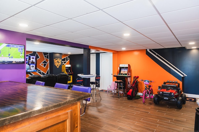 recreation room featuring wood finished floors, a paneled ceiling, and recessed lighting