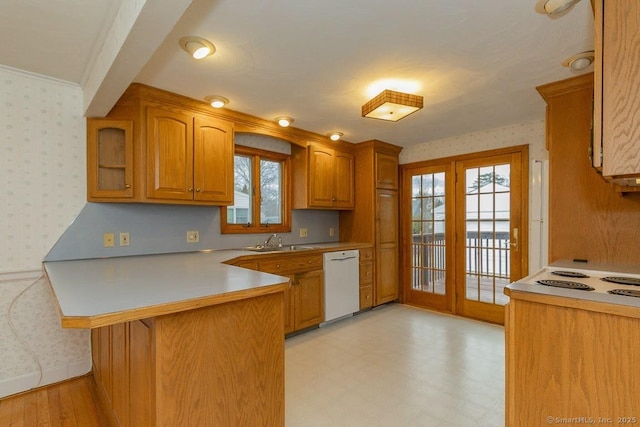 kitchen featuring dishwasher, wallpapered walls, and a sink