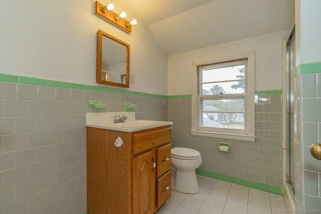 full bathroom with vanity, tile patterned floors, toilet, tile walls, and a shower with door