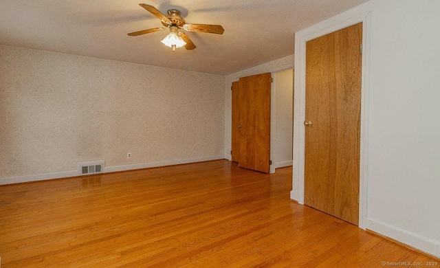 spare room with visible vents, ceiling fan, baseboards, and light wood-style floors