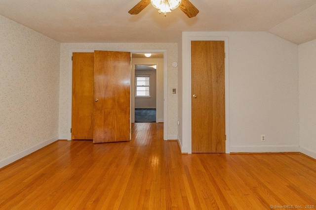 spare room featuring light wood-type flooring, baseboards, a ceiling fan, and wallpapered walls