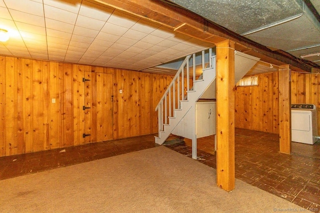 finished below grade area featuring washer / dryer, carpet, stairs, and wood walls