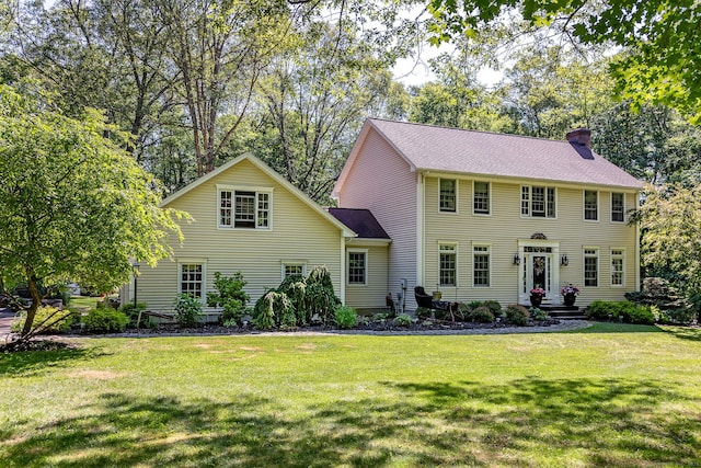 colonial house with a chimney and a front yard