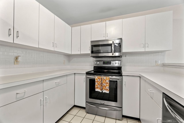 kitchen with light countertops, light tile patterned floors, backsplash, and stainless steel appliances