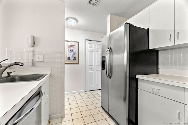 kitchen featuring visible vents, a sink, appliances with stainless steel finishes, light tile patterned flooring, and light countertops