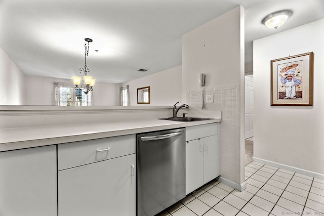 kitchen featuring light tile patterned flooring, a sink, light countertops, stainless steel dishwasher, and a chandelier