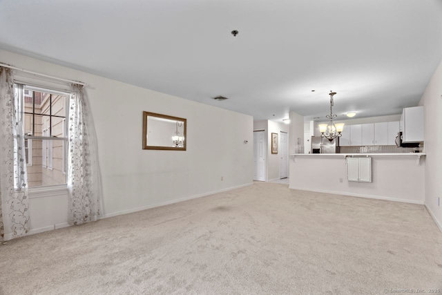 unfurnished living room with light carpet, a chandelier, visible vents, and baseboards