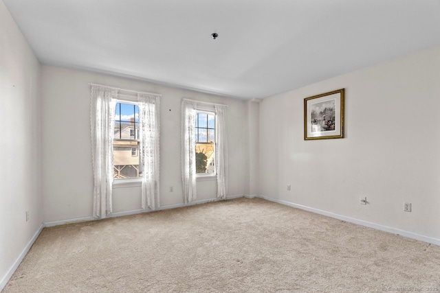 unfurnished room with baseboards and carpet